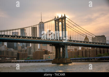 Sonnenuntergang und Boote auf dem East River unter der Brücke am 04.07.2018 zum Unabhängigkeitstag / sunset ship on east river under bridge Stock Photo