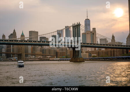 Sonnenuntergang und Boote auf dem East River unter der Brücke am 04.07.2018 zum Unabhängigkeitstag Empire / sunset ship on east river under bridge Stock Photo