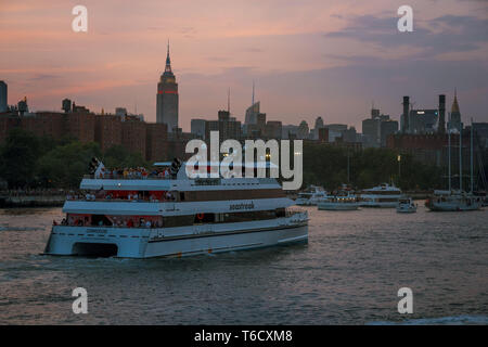 Sonnenuntergang und Boote auf dem East River unter der Brücke am 04.07.2018 zum Unabhängigkeitstag / sunset ship on east river under bridge Stock Photo