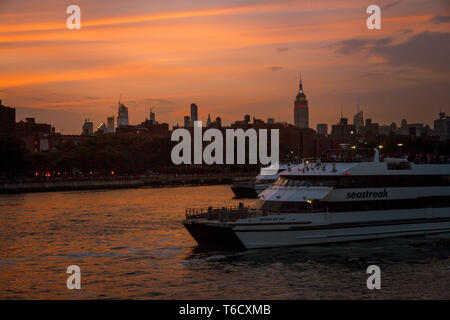 Sonnenuntergang und Boote auf dem East River unter der Brücke am 04.07.2018 zum Unabhängigkeitstag / sunset ship on east river under bridge Stock Photo