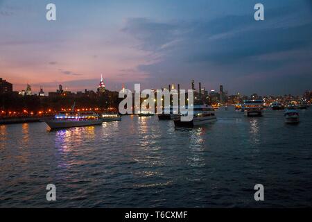 Sonnenuntergang und Boote auf dem East River unter der Brücke am 04.07.2018 zum Unabhängigkeitstag / sunset ship on east river under bridge Stock Photo