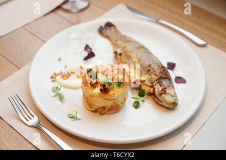 Pan fried rainbow trout with potato casserole on plate Stock Photo