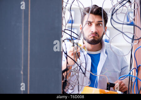 Electrician trying to untangle wires in repair concept Stock Photo