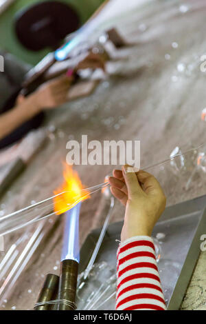 Hands of a glassblower woman Stock Photo