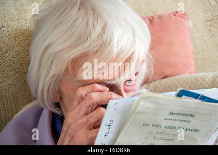 struggling to read text with a magnifying loupe for visually impaired people (VIP's) Stock Photo