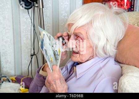 struggling to read text with a magnifying loupe for visually impaired people (VIP's) Stock Photo