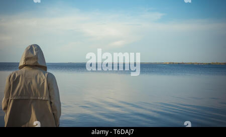 The pensive man standing near the sea. The man looking at the horizon Stock Photo