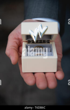 Best Man holding wedding rings in a box on the palms of his hands Stock Photo
