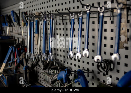 Repairman's workshop, close-up low-key image. Well organised workplace of a mechanic, rows of spanners and other tools, close-up view