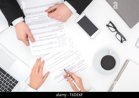 Two business people sitting at office top view close-up reading documents together discussing contract cooperation Stock Photo