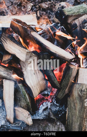 High angle close up of burning wooden logs of a campfire in a forest. Stock Photo