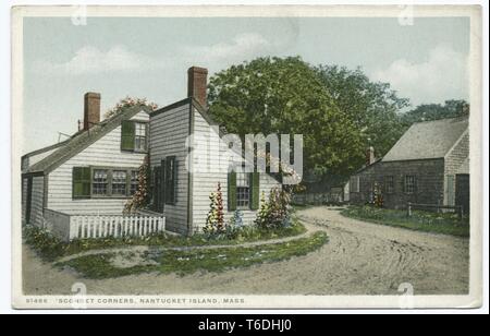 Postcard with a color image depicting a view of a small, white wooden house, with a steeply pitched, green, shingled roof, green shutters, flowers growing at the perimeter, and a floral vine on the roof, with a brown, shingled building and trees visible in the right background; located in Siasconset on Nantucket Island, Massachusetts, 1914. From the New York Public Library. () Stock Photo