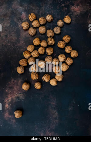 High angle close up of walnuts on black rusty surface. Stock Photo