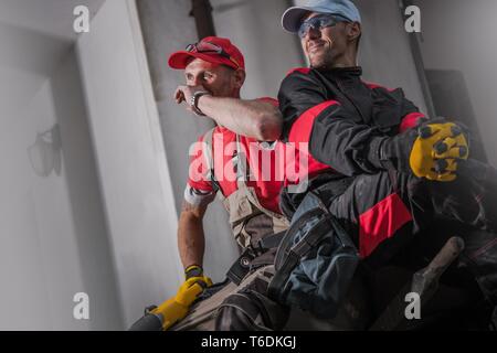 Construction Site Crew. Two Caucasian Workers Taking Short Break. Industrial Theme. Stock Photo