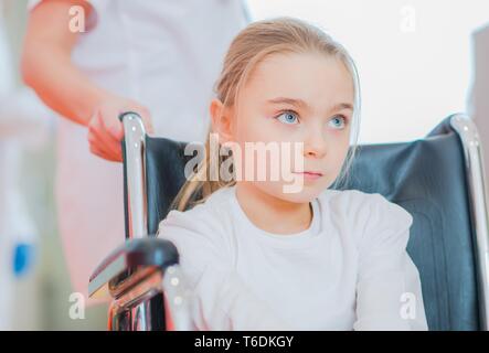 Disabled Caucasian Girl on a Wheelchair Inside Rehabilitation Center. Health Care Theme. Stock Photo