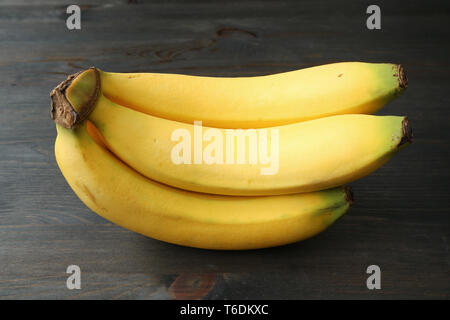 Bunch of bananas isolated on dark color wooden background Stock Photo