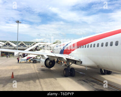 KEDAH, LANGKAWI, MALAYSIA - APR 11th, 2015: View of a plane wing and the turbine engine of airplane operated by Malaysia Airlines with a part of its Stock Photo