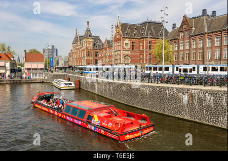 Amsterdam, Netherlands - 22 April 2019: Tourists sightseeng at Canal Boat City Hopper near the Central Station of Amsterdam. Stock Photo