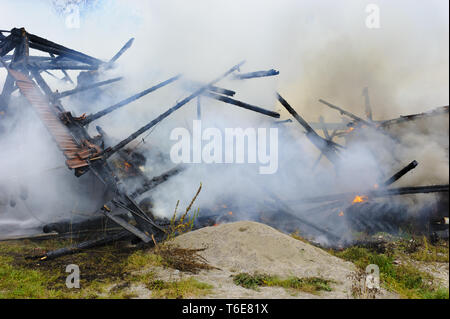 Firefighter in action at burning farm house in Germany Stock Photo