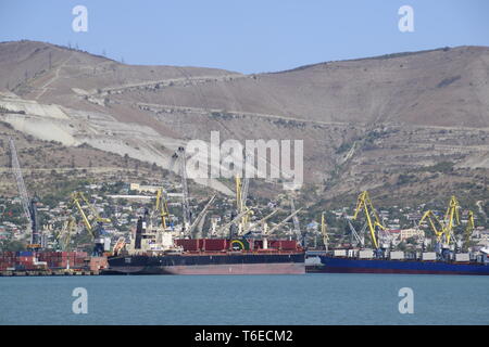 Cargo port with port cranes. Sea bay and mountainous coast. Stock Photo