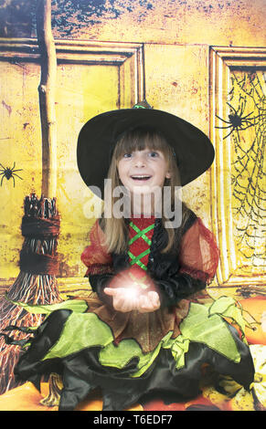 Little girl all dressed up for Halloween. On a Halloween background. Stock Photo