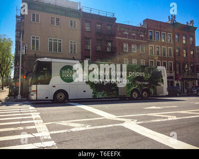 A bus wrapped in an advertisement for Amazonâ€™s Whole Foods Market promoting their lower prices in the Chelsea neighborhood of New York on Tuesday, April 23, 2019.  (Â© Frances M. Roberts) Stock Photo