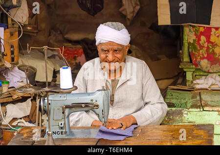Egyptian tailor at sewing machine in open air tailor stand. Stock Photo