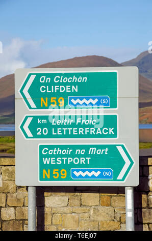 Bilingual road sign English and Irish Gaelic with Wild Atlantic Way tourist rotue  wave symbols   Galway Ireland Stock Photo