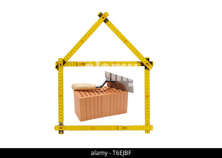 shell of house under construction with folding ruler in hand of real estate agent Stock Photo