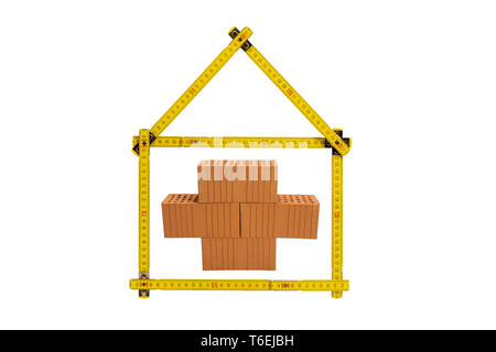 shell of house under construction with folding ruler in hand of real estate agent Stock Photo