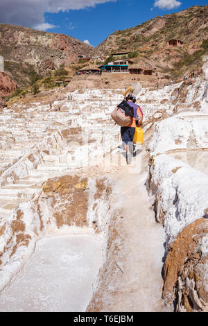 Worker at family-owned Salt-evaporation ponds of Maras mines in the Sacred Valley, Cusco Region, Peru Stock Photo