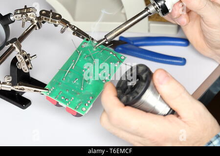 worker is soldering some electrical devices Stock Photo