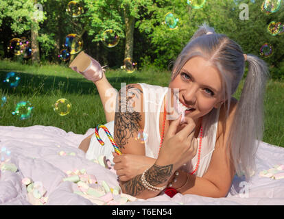 Cute attractive young woman eating marshmallows Stock Photo