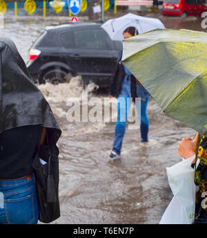 People in flooded rainy city Stock Photo