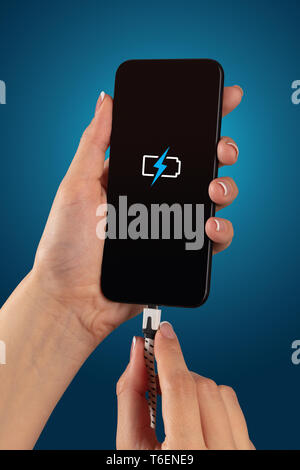 Elegant hand charging cellphone with low battery  Stock Photo