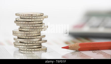 stacked euro coins and calculator laying on financial business chart of stock market Stock Photo