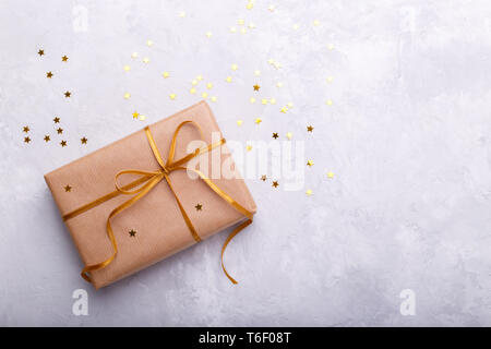 Gift box wrapped in gold wrapping paper, decorated with red raffia ribbon  and bow isolated on the white background Stock Photo - Alamy