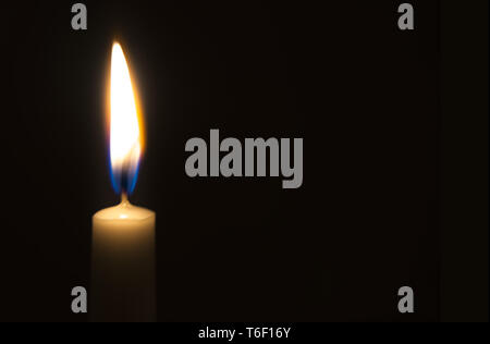 One light candle burning brightly in the black background Stock Photo