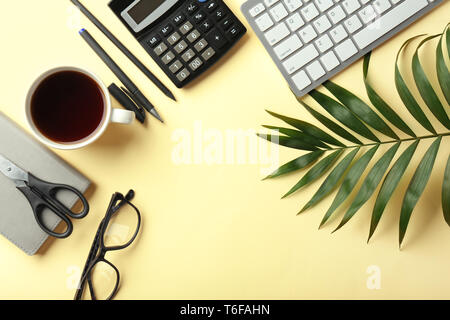 Computer keyboard, cup of coffee and calculator on color background, flat lay. Workplace table composition Stock Photo