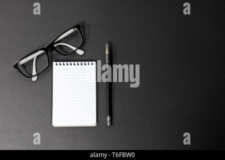 Generic glasses, notepad and pen in a black and white theme flat lay, business, modern, minimal concept Stock Photo