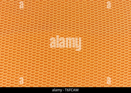 Honeycomb textured cloth flat lay, interesting hexagonal repeating pattern orange and yellow in colour Stock Photo