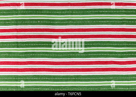 Red, white & green striped Christmas cloth laying flat for background and texture with the stripes in horizontal direction Stock Photo