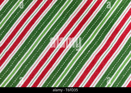 Red, white & green striped Christmas cloth laying flat for background and texture with the stripes in diagonal direction Stock Photo