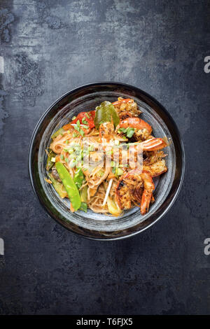 Traditional Thai Phak Kung curry with barbecue king prawns and noodles as top view in a bowl Stock Photo