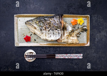 Traditional Japanese barbecue Kama Yaki salmon fish head as close-up on a plate Stock Photo