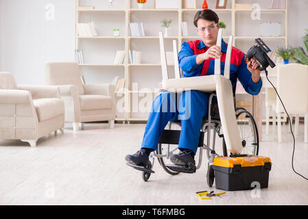 Disabled man repairing chair in workshop Stock Photo