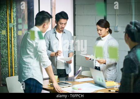 young asian entrepreneurs of small company discussing business plan in office meeting room. Stock Photo