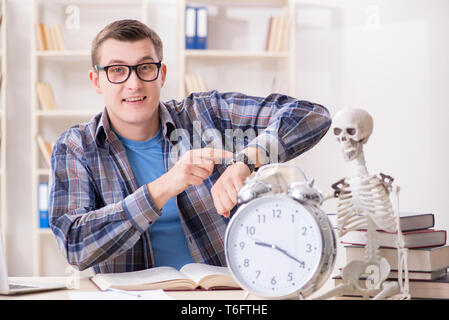 Student and skeleton preparing for school exams Stock Photo