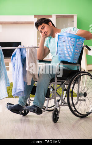 Disabled man on wheelchair doing laundry Stock Photo