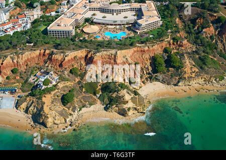 AERIAL VIEW. Luxury resort overlooking the colorful cliffs of Praia da Falésia on the Atlantic shores. Olhos de Agua, Albufeira, Algarve, Portugal. Stock Photo